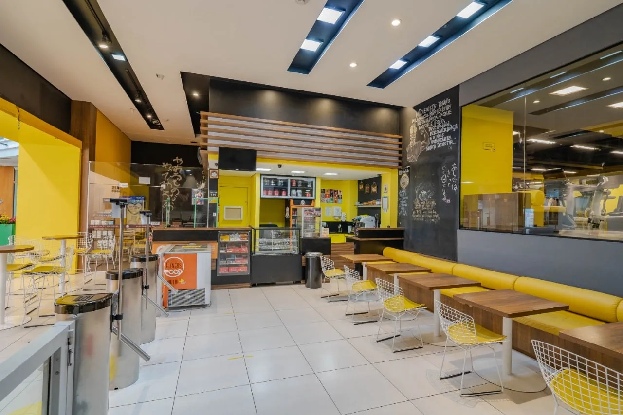 Lounge da recepção, com mesas e cadeiras amarelas