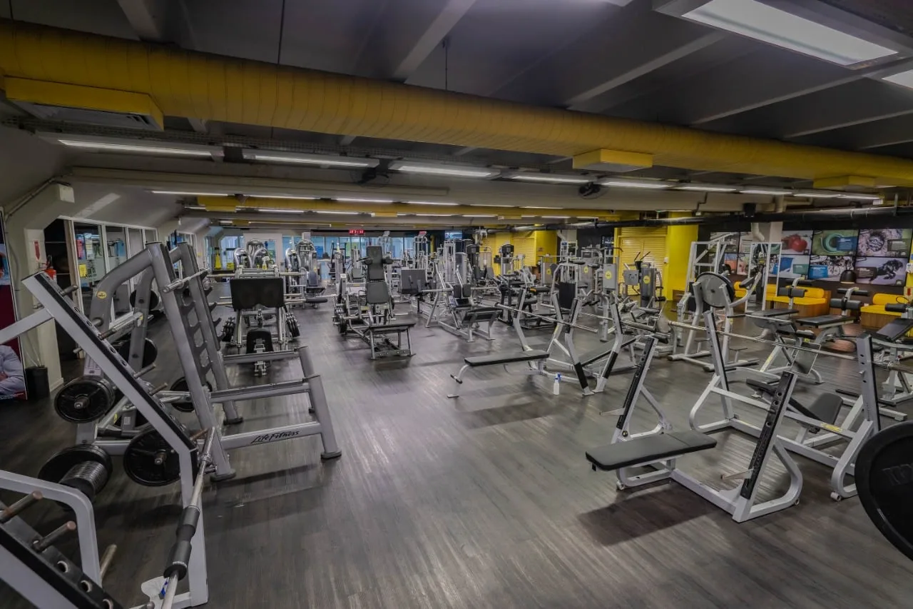 Sala de musculação ampla, com equipamentos alinhados